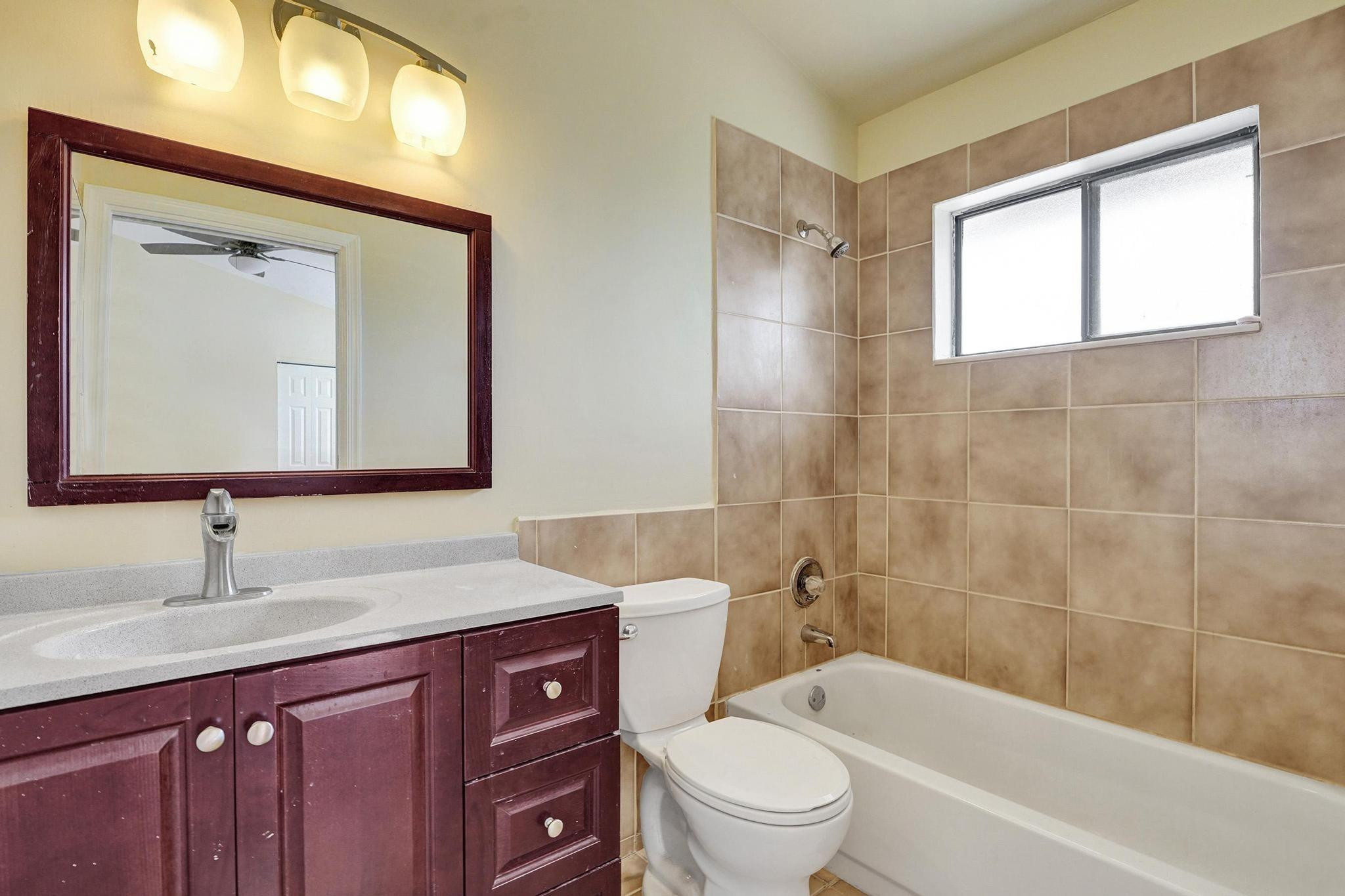 5425 Cleveland Road Delray Beach, FL 33484 - Photo 30 of 39 a bathroom with a bathtub shower sink vanity mirror and toilet