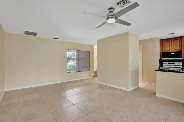 a view of an empty room with window and cabinet