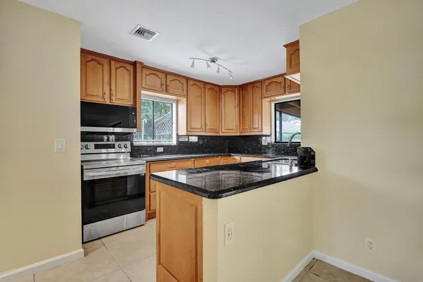 a kitchen with granite countertop a sink and a stove top oven