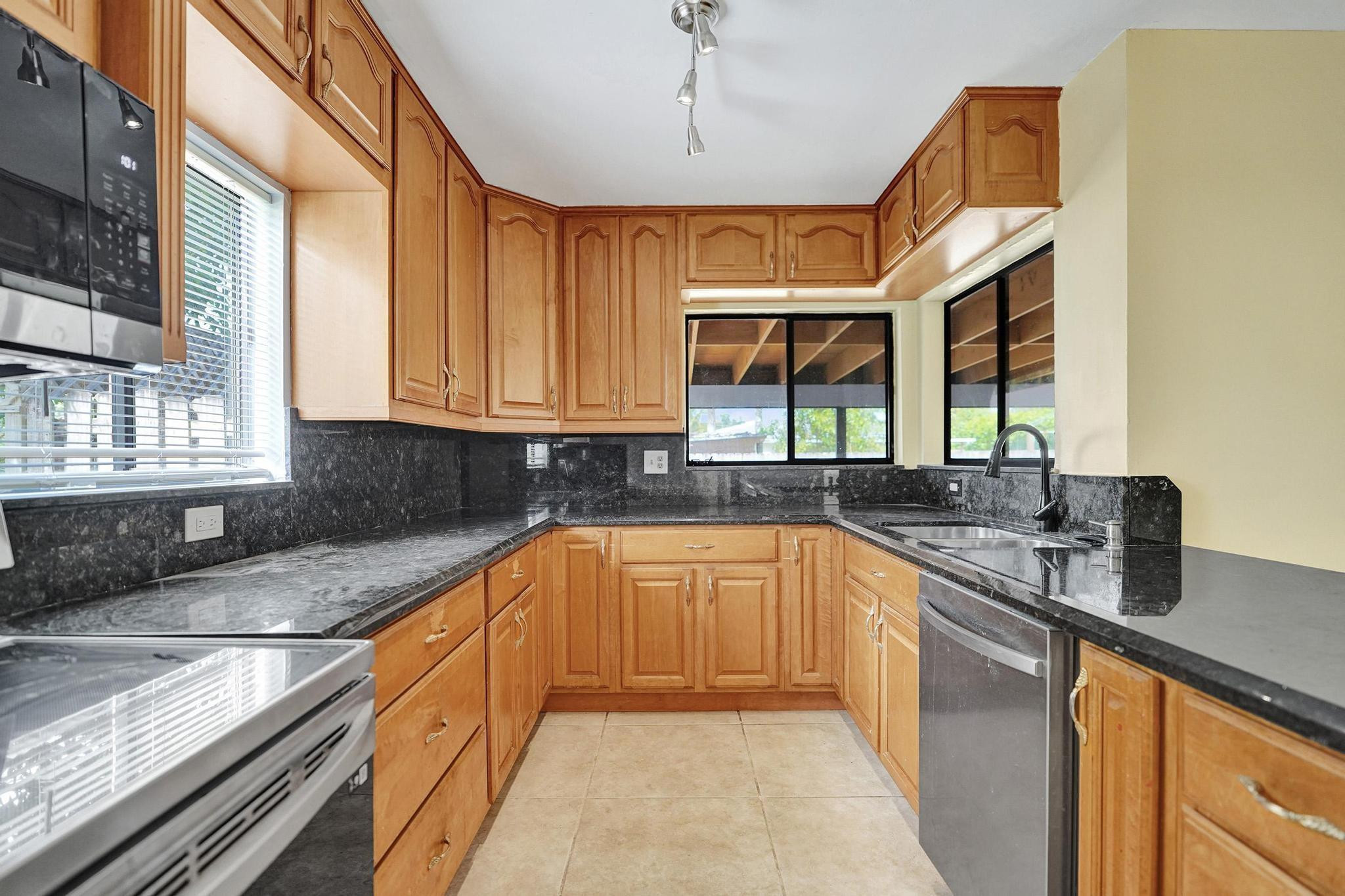 5425 Cleveland Road Delray Beach, FL 33484 - Photo 9 of 39 a kitchen with stainless steel appliances granite countertop a sink a stove and cabinets