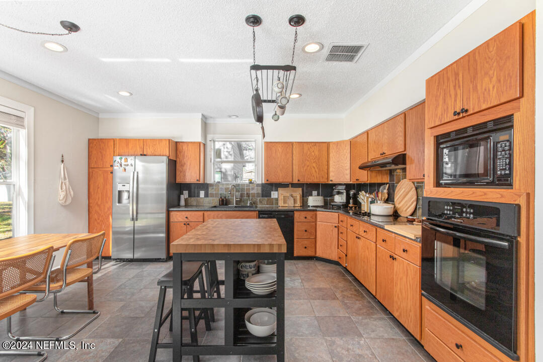 9644 Beauclerc Bluff Road Jacksonville, FL 32257 - Photo 14 of 48 a kitchen with stainless steel appliances granite countertop a stove a sink and a refrigerator