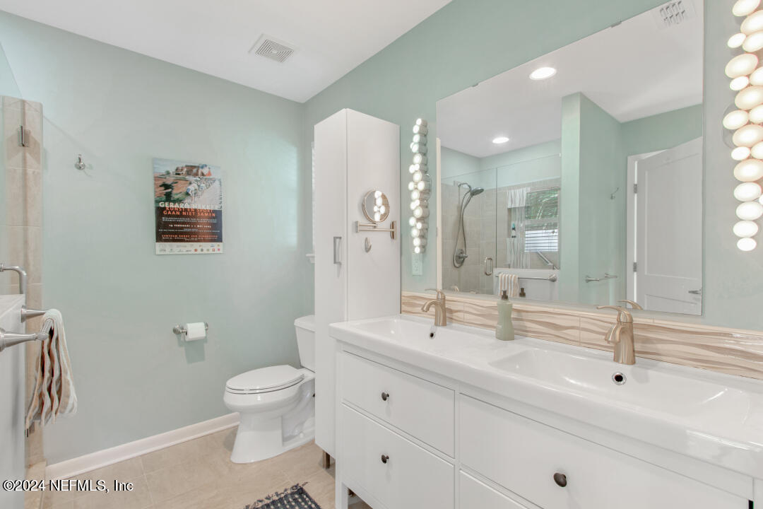 9644 Beauclerc Bluff Road Jacksonville, FL 32257 - Photo 46 of 48 a bathroom with a double vanity sink toilet and a mirror
