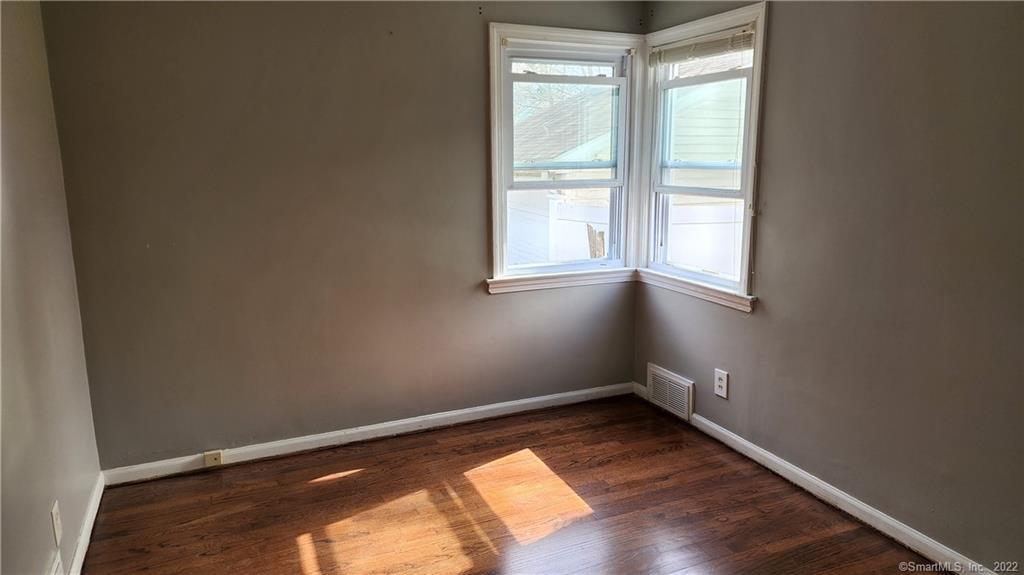 25 Madsen Road West Hartford, CT 06110 - Photo 9 of 16 an empty room with wooden floor and windows