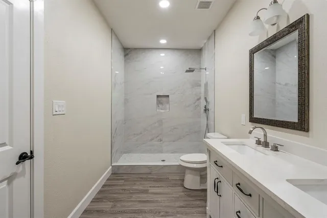 a bathroom with a double vanity sink toilet and shower