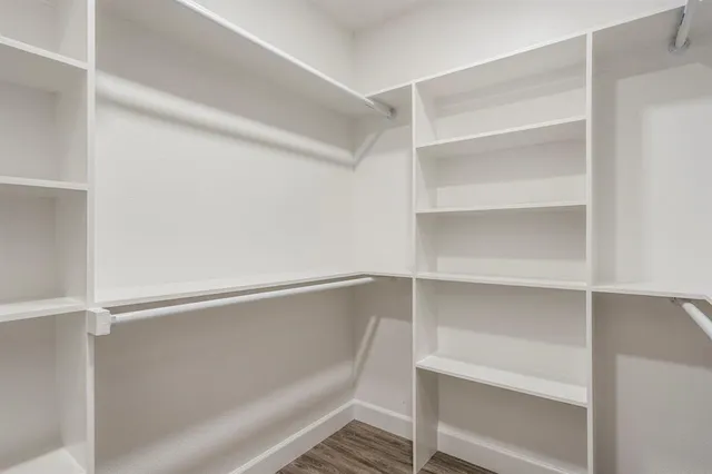 a view of walk in closet with empty racks