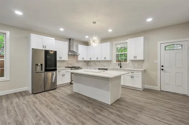 a kitchen with a refrigerator and a stove top oven