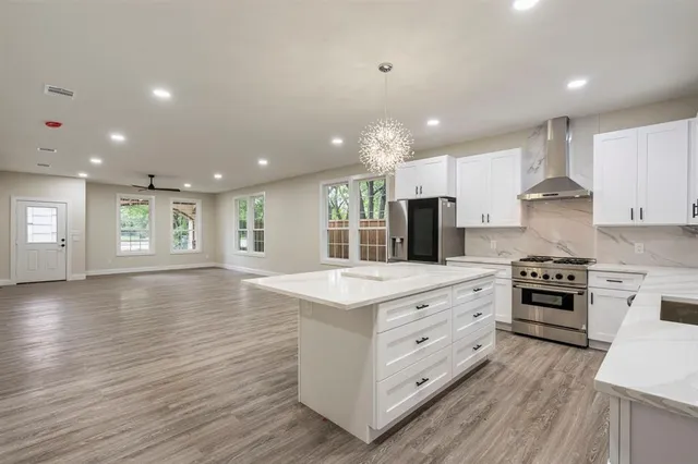a kitchen with stainless steel appliances kitchen island granite countertop a stove and a sink