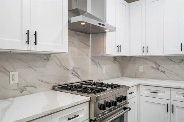 a white stove top oven sitting inside of a kitchen