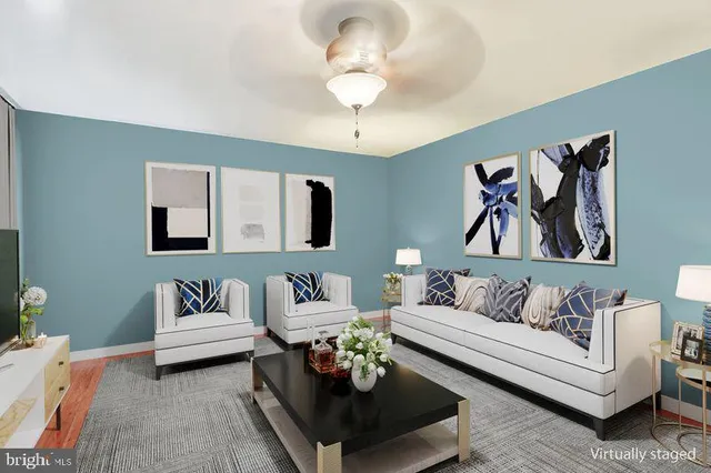 a dining room with furniture a rug a potted plant and wooden floor