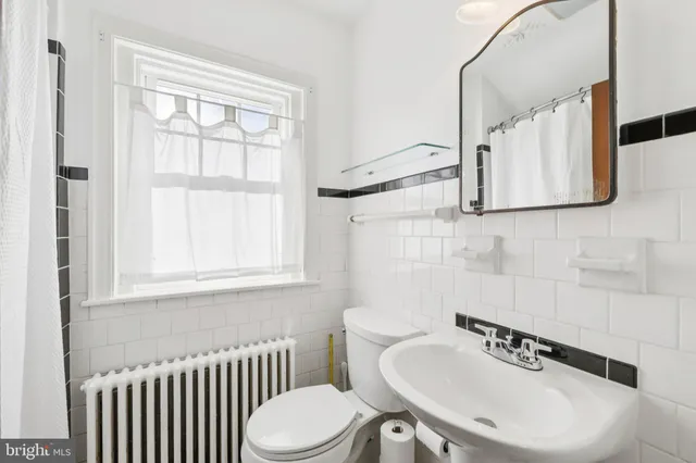a living room with a couch and a dresser next to a window