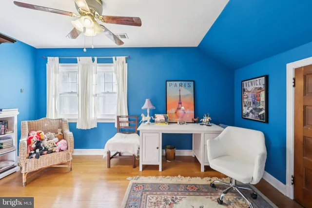 a living room with stainless steel appliances furniture a rug and a kitchen view