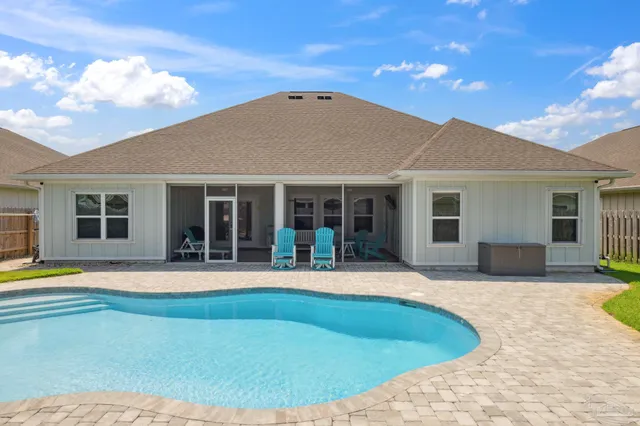 an aerial view of a house with a swimming pool and lake view