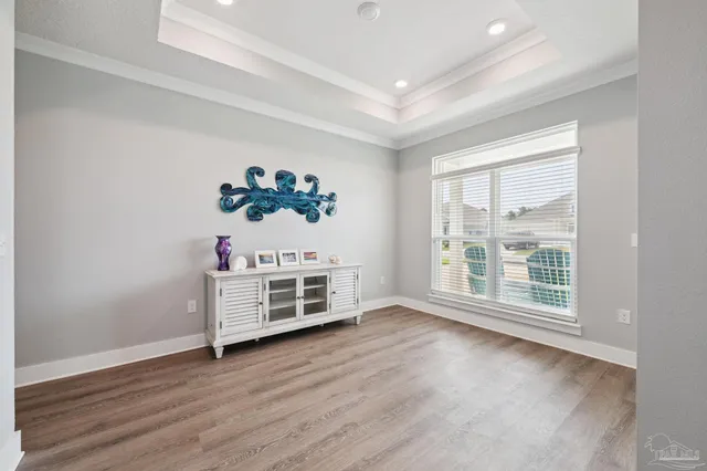 an empty room with wooden floor and window