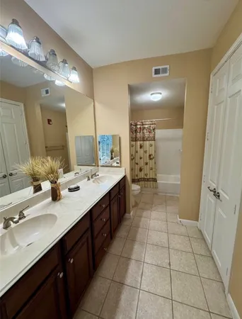 a bathroom with a double vanity sink mirror and shower