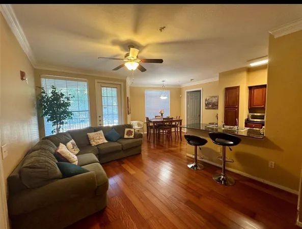 a living room with furniture a wooden floor and a chandelier