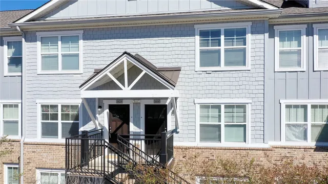 a front view of a house with wooden chairs and a table
