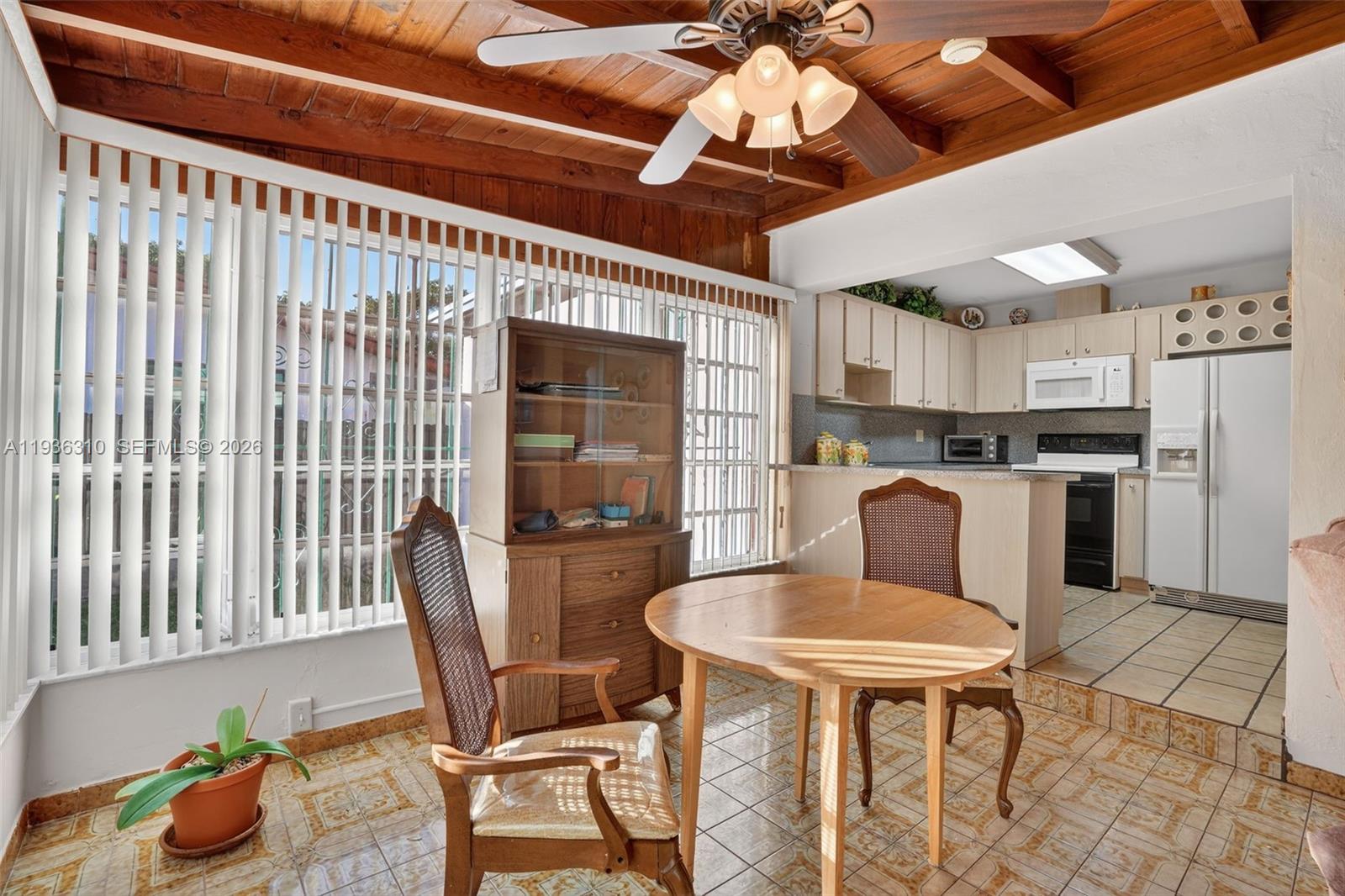 1633 Southwest 30th Avenue Miami, FL 33145 - Photo 11 of 30 a kitchen with stainless steel appliances kitchen island granite countertop a table chairs and a refrigerator