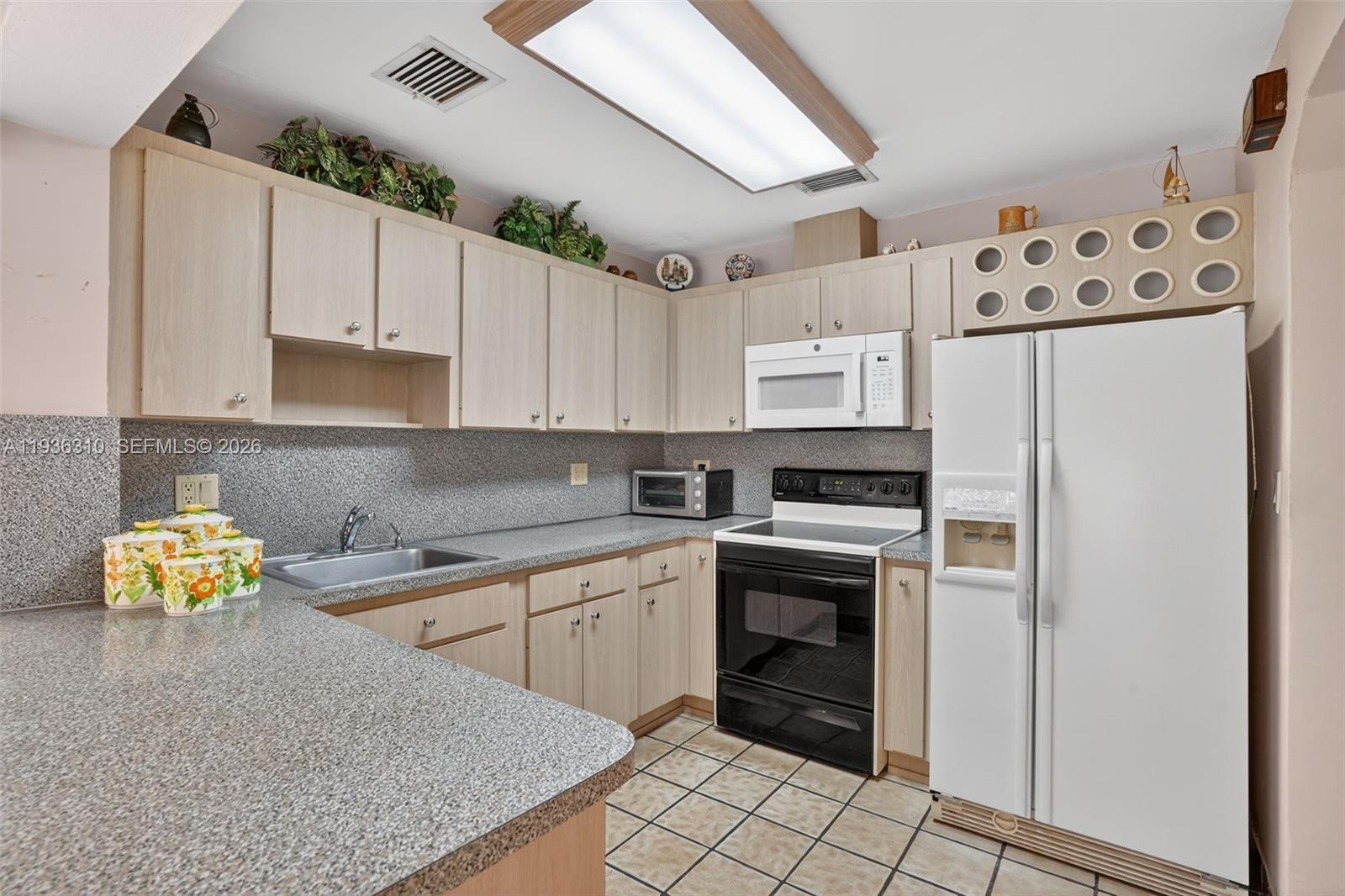 1633 Southwest 30th Avenue Miami, FL 33145 - Photo 10 of 30 a kitchen with stainless steel appliances granite countertop a refrigerator and a stove top oven