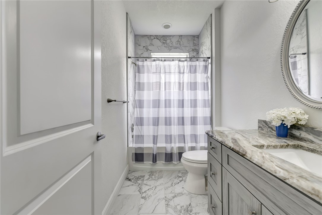5513 Spanish River Road Fort Pierce, FL 34951 - Photo 11 of 33 a bathroom with a granite countertop sink a toilet a mirror and shower