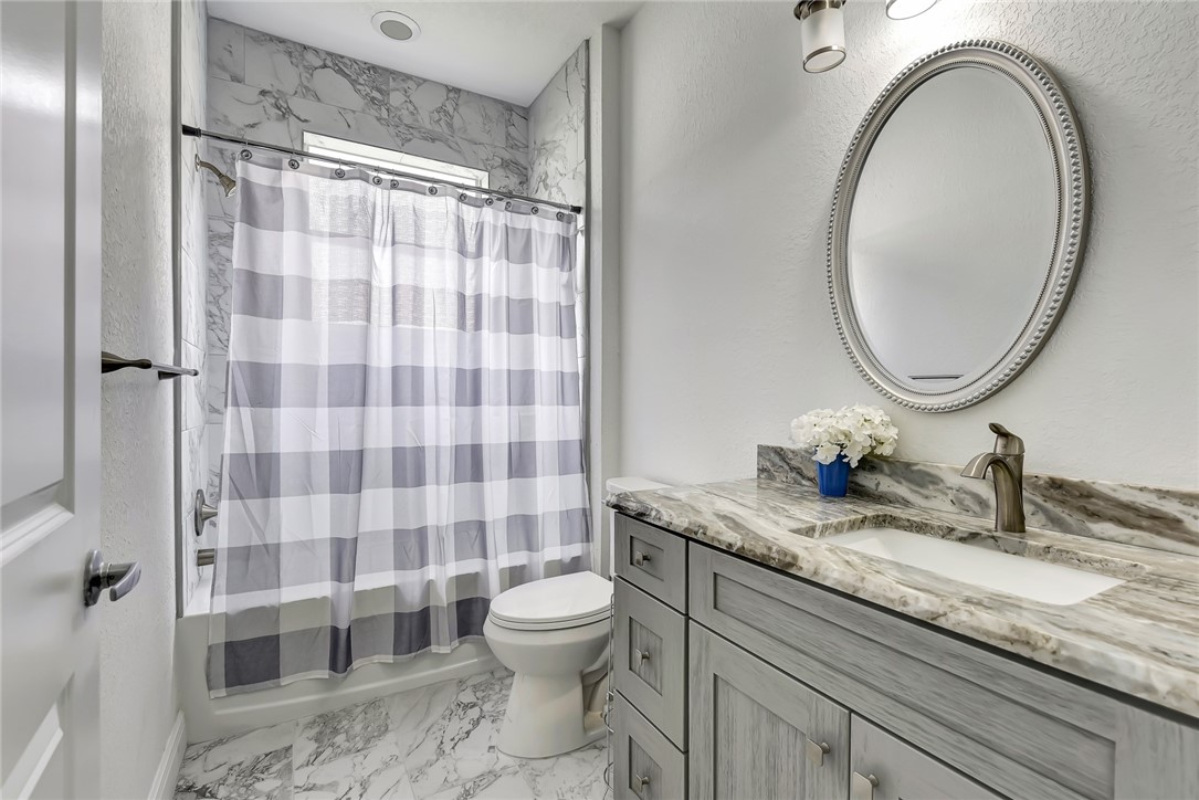 5513 Spanish River Road Fort Pierce, FL 34951 - Photo 12 of 33 a bathroom with a granite countertop sink a toilet and a mirror