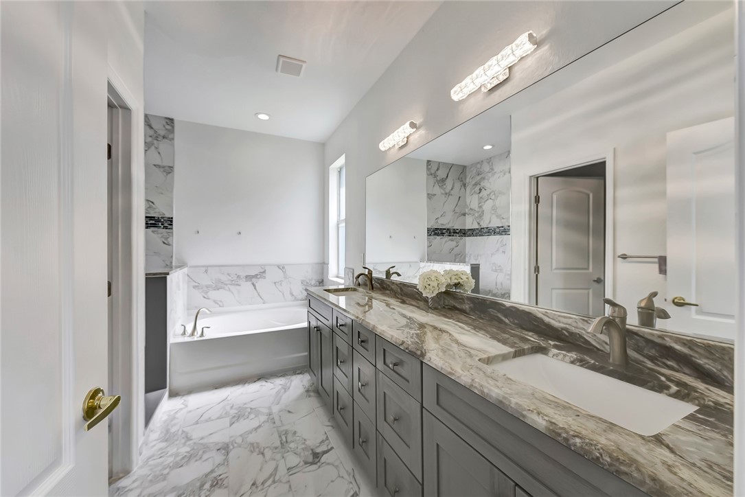 5513 Spanish River Road Fort Pierce, FL 34951 - Photo 16 of 33 a bathroom with a granite countertop double vanity sink a mirror and a bathtub