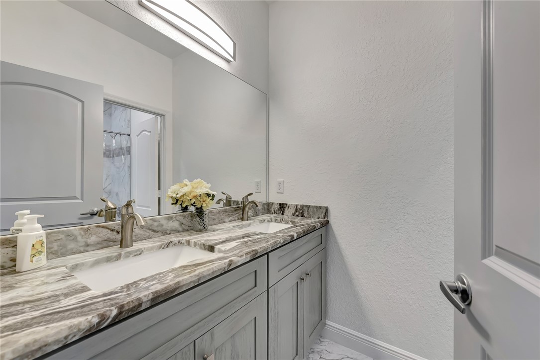 5513 Spanish River Road Fort Pierce, FL 34951 - Photo 18 of 33 a bathroom with double sink and a mirror