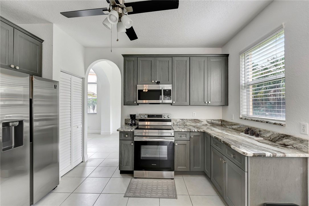 5513 Spanish River Road Fort Pierce, FL 34951 - Photo 2 of 33 a kitchen with granite countertop a stove sink and refrigerator