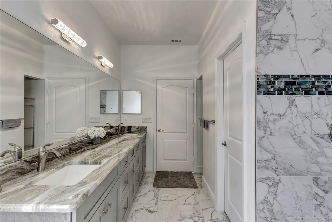 5513 Spanish River Road Fort Pierce, FL 34951 - Photo 28 of 33 a bathroom with a granite countertop sink a mirror a vanity and a shower