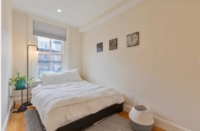 a bedroom with a bed and a potted plant