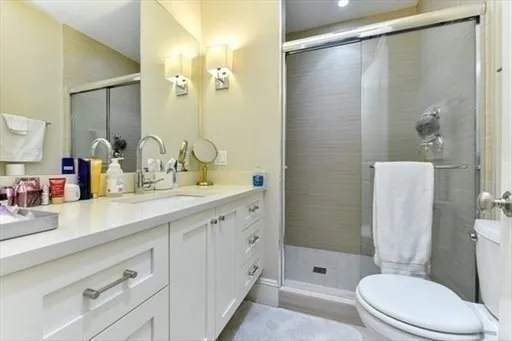 a bathroom with a double vanity sink toilet and shower
