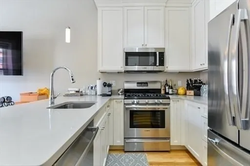 a kitchen with stainless steel appliances granite countertop a sink stove and refrigerator