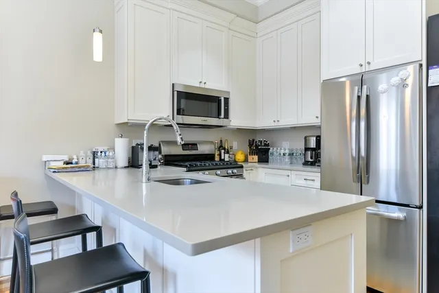 a kitchen with stainless steel appliances a refrigerator sink and white cabinets