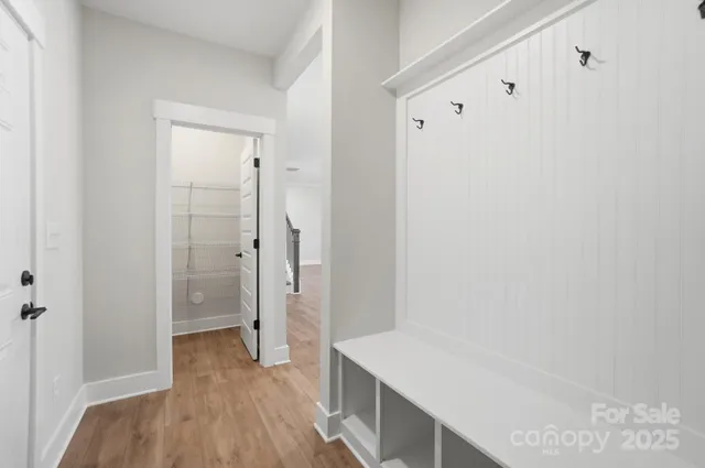 an empty room with wooden floor fireplace and windows