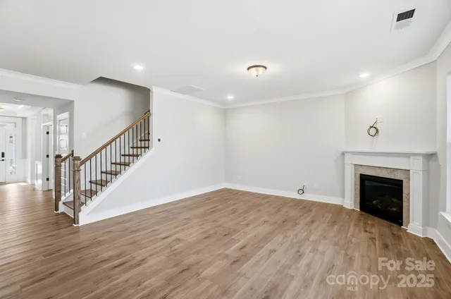 a view of empty room with wooden floor and fireplace