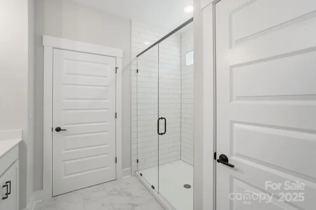 a bathroom with a double sink shower and mirror