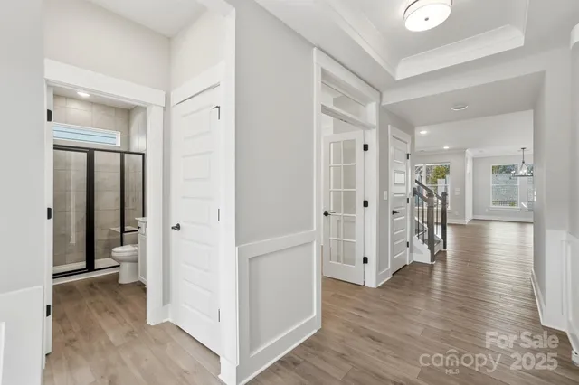 a view of a hallway with wooden floor and closet
