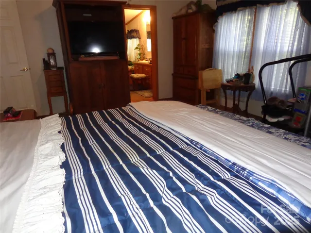 a bedroom with a bed and dresser with mirror