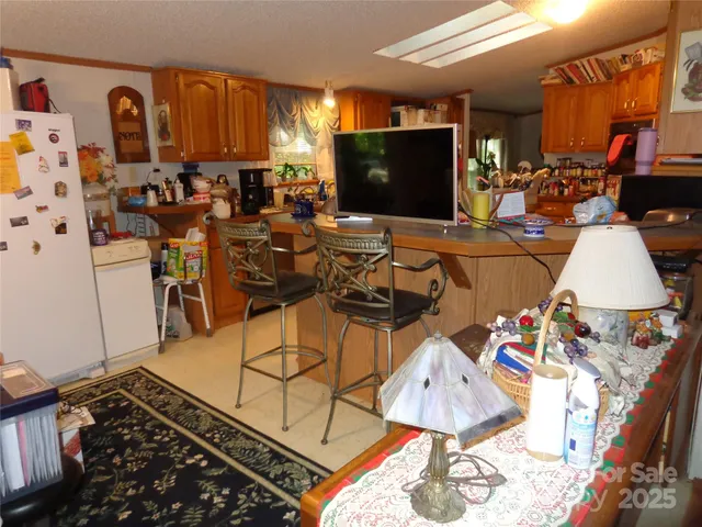 a kitchen with stainless steel appliances kitchen island granite countertop a refrigerator and a wooden cabinets