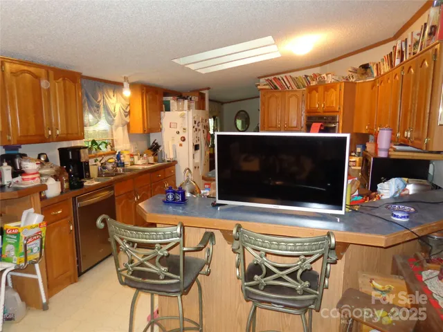 a view of a kitchen with refrigerator and a stove