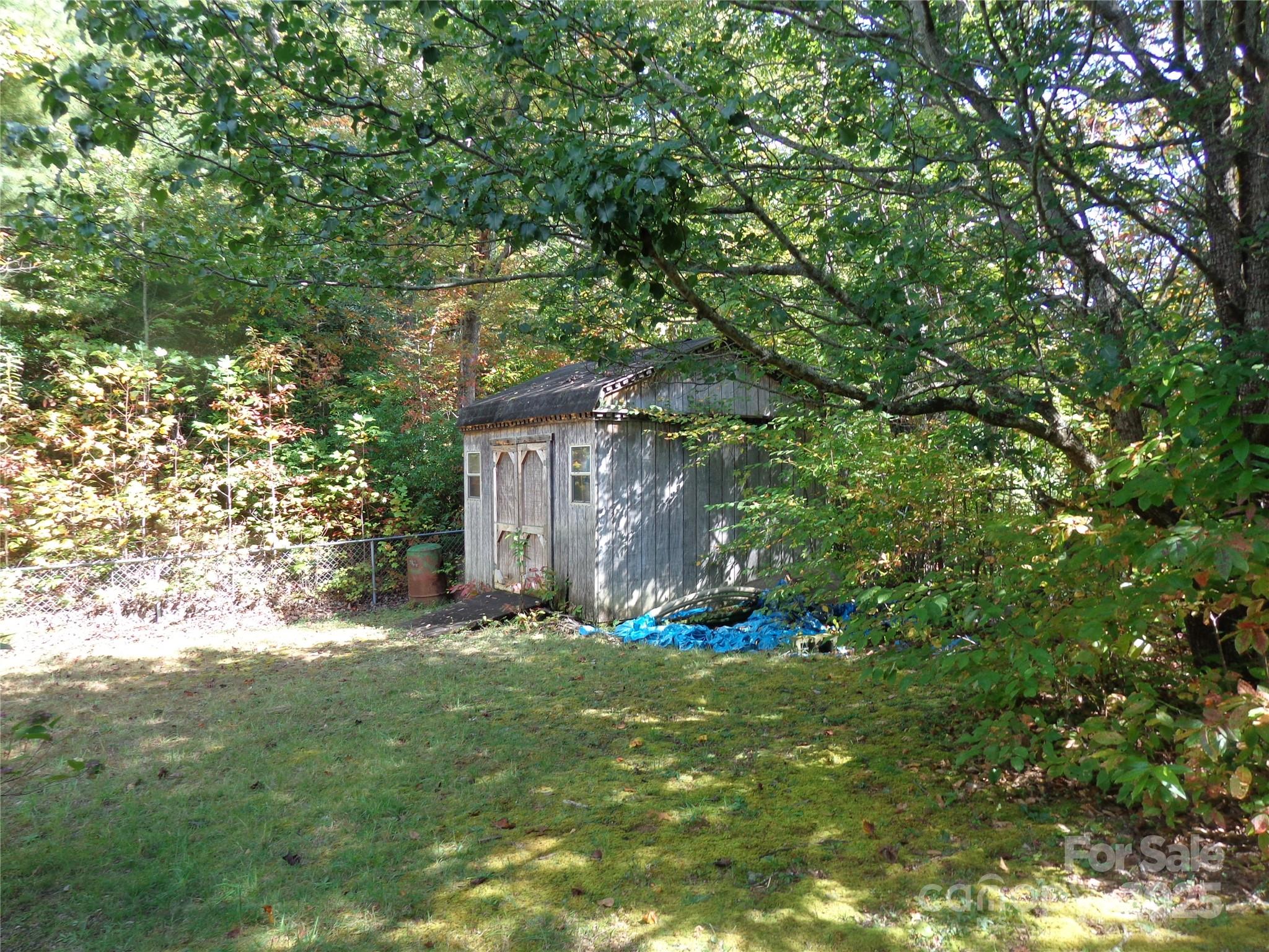 89 Blue Mountain Road Fairview, NC 28730 - Photo 9 of 40 a backyard of a house with table and chairs