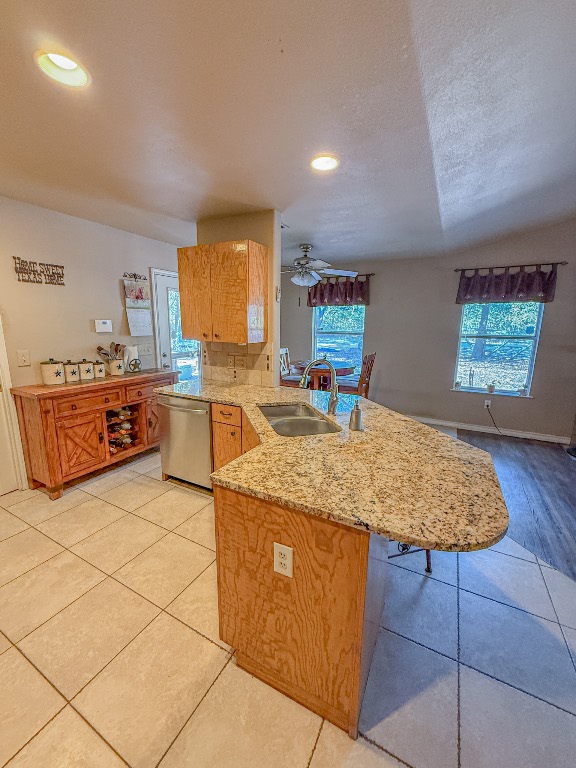 Undisclosed Address Georgetown, TX 78633 - Photo 18 of 37 Kitchen featuring light tile patterned floors, dishwasher, healthy amount of natural light, light stone counters, and recessed lighting