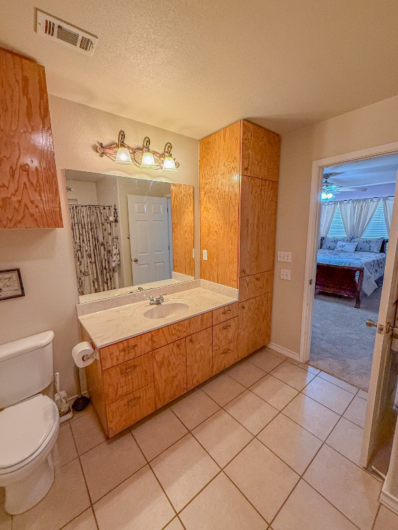 Undisclosed Address Georgetown, TX 78633 - Photo 29 of 37 Full bathroom with vanity, light tile patterned floors, a textured ceiling, connected bathroom, and a shower with curtain