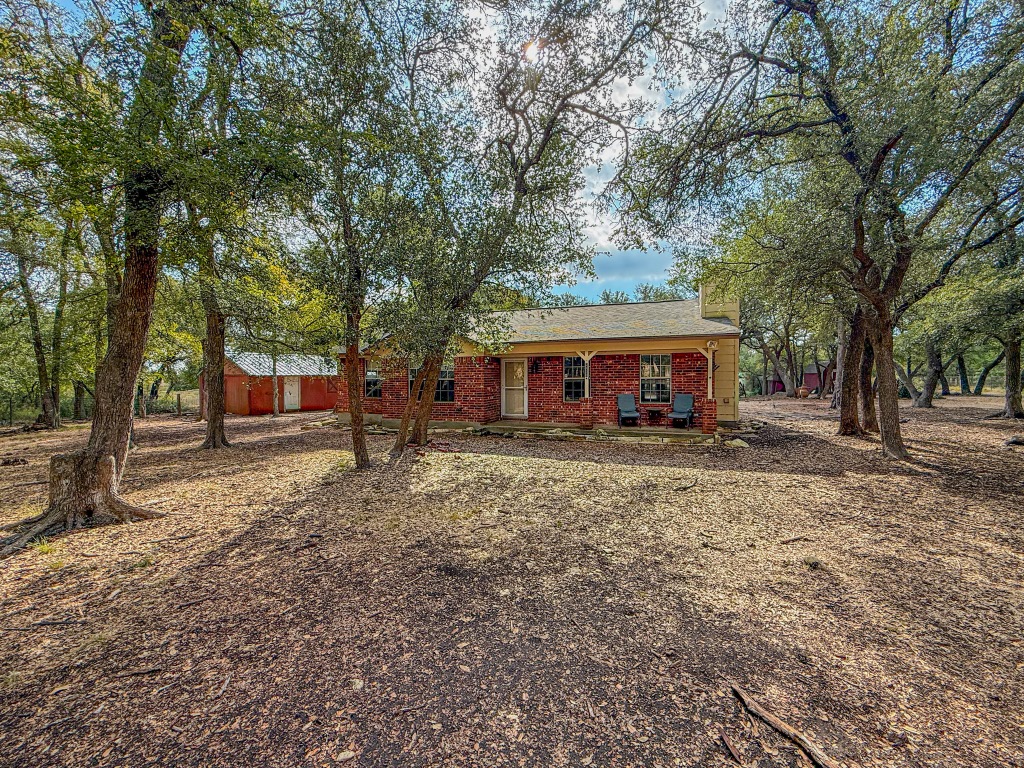 Undisclosed Address Georgetown, TX 78633 - Photo 4 of 37 Rear view of house featuring brick siding, a chimney, and covered porch