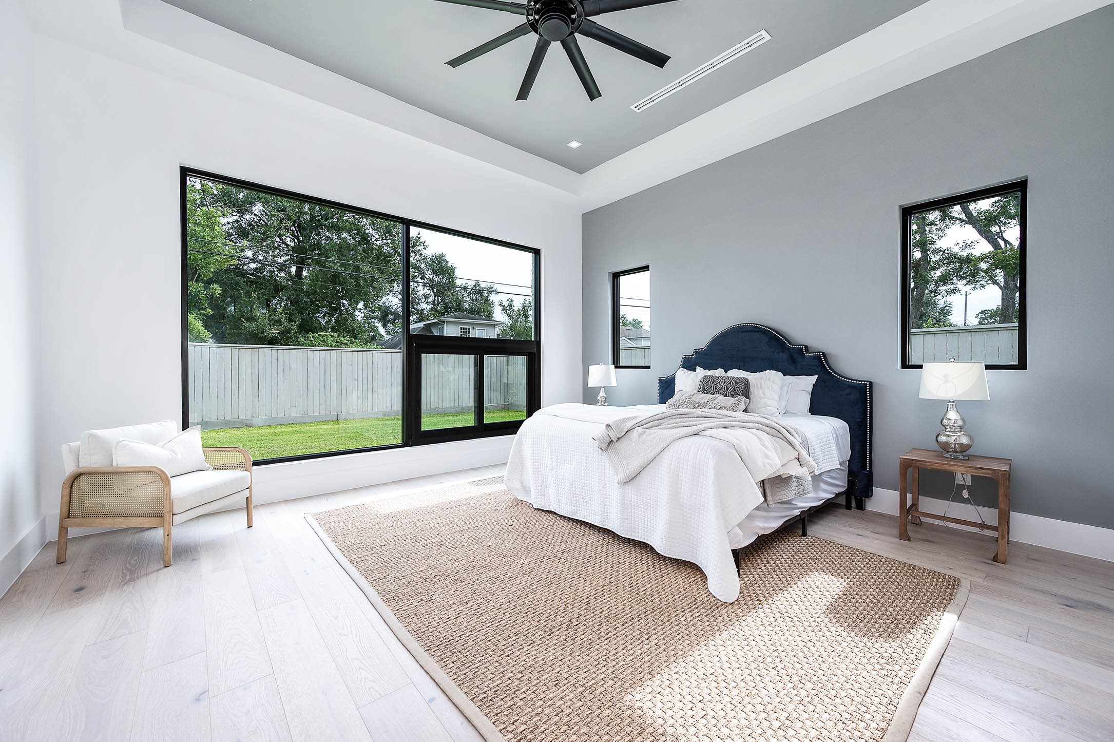 207 West 33rd Street Houston, TX 77018 - Photo 21 of 50 Primary bedroom with a large-format custom window showcasing abundant natural light and backyard views, creating a bright and spacious retreat.