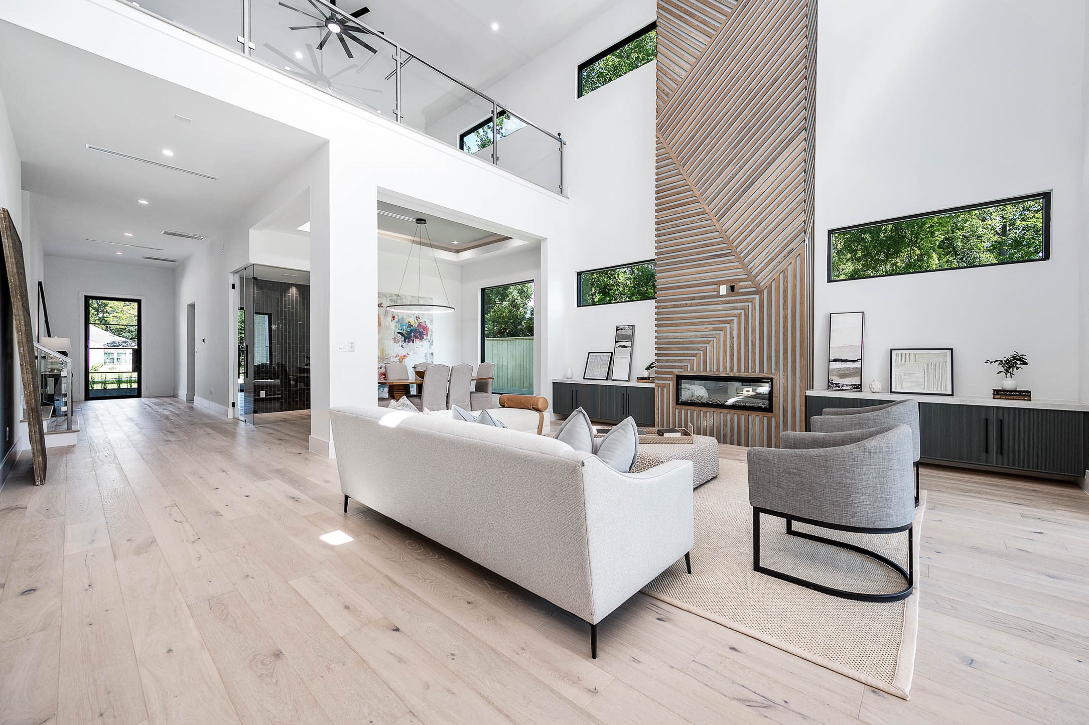 207 West 33rd Street Houston, TX 77018 - Photo 8 of 50 Spacious living area with soaring 23-foot ceilings and an open upstairs loft overlooking the space, creating an airy and grand atmosphere.