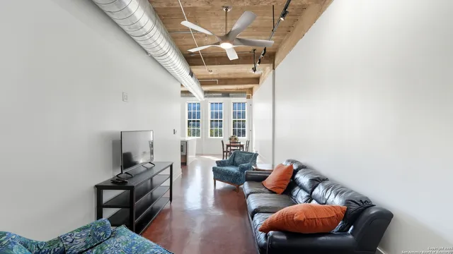 a living room with furniture a ceiling fan and a rug