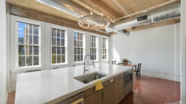 a view of a kitchen with a sink and large windows