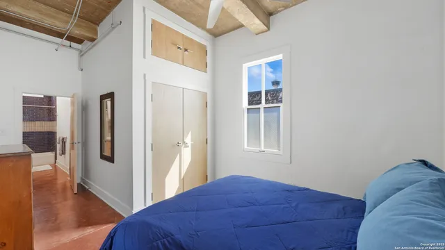 a bedroom with a bed and wooden floor