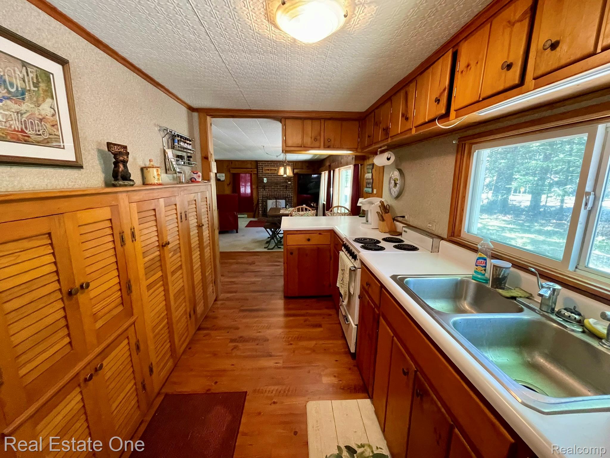 2596 Fox Road Lincoln, MI 48742 - Photo 26 of 54 Galley kitchen featuring wood-finish flooring, wood cabinetry, and a double basin stainless steel sink