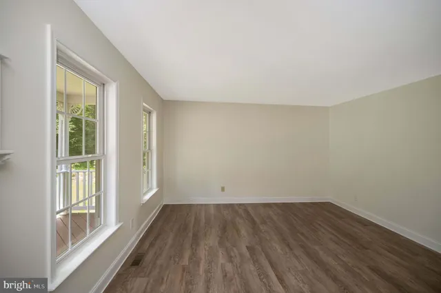 a view of a hallway with wooden floor and stairs